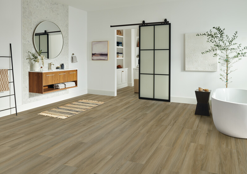 Bathroom with a floating sink, sliding door to a dressing room, and gray-toned hardwood flooring